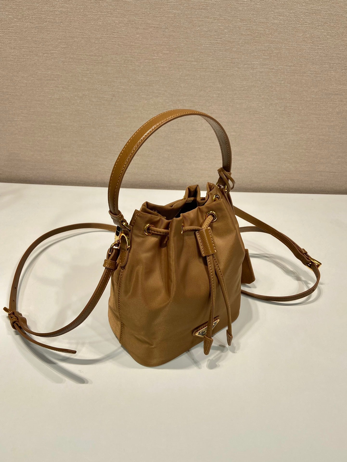 PRADA BUCKET BAG 19 IN RUSSET BROWN RE-NYLON AND CALFSKIN HANDLE